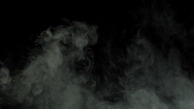 Smoke or fog moving on the ground, approaching fog on a green chrome key background, fog creeping along the floor and approaching the viewer, seamless loop of smoke. White smoke horizontal motion