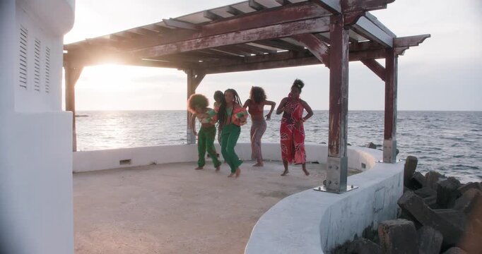 Five colombian girls dancing salsa attractively on a pier, Cartagena