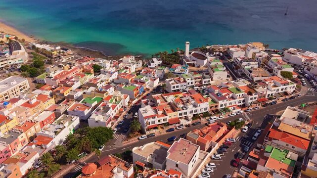 Ambient drone exploration of the Morro Jable town known for its beaches, like vast Playa del Matorral, with its Morro Jable Lighthouse. Drone POV of Fuertaventura Island.