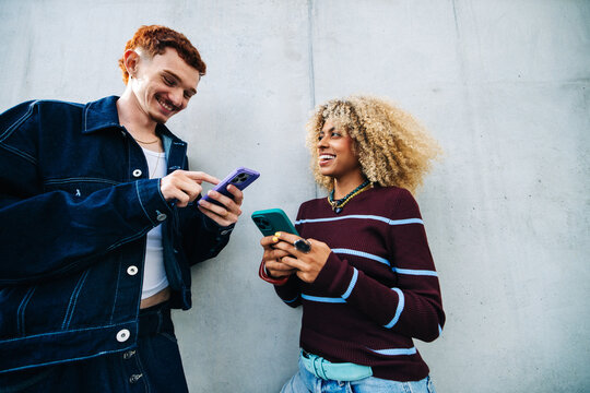 Friends sharing smartphone moments with young urban style