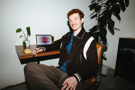 Young man working at desk with laptop in casual home office workspace