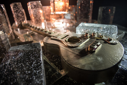 Music Concept: Guitar Miniature on a Dark Background with Vivid Light, Smoke, and Fire Effects. Golden electro guitar under a Dramatic Spotlight.