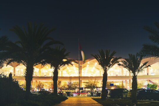 Amman, Jordan - 17th december, 2025: Amman Jordan airport terminal timelapse at night, glowing facade, palm trees, cars moving, travel gateway, aviation infrastructure, urban mobility concept