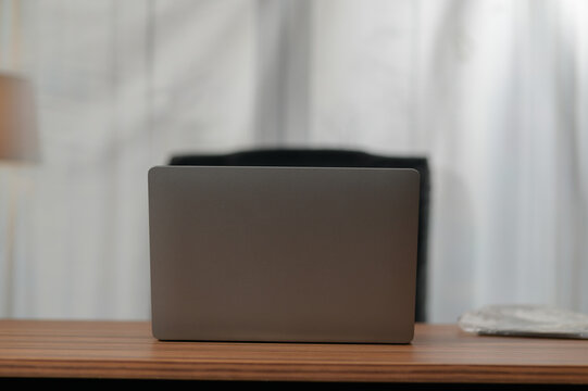 Minimalist workspace with closed laptop on wooden table in bright room