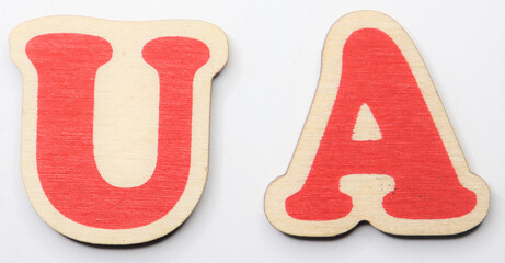 Red wooden letters u and a on white background © PROKOPYCH