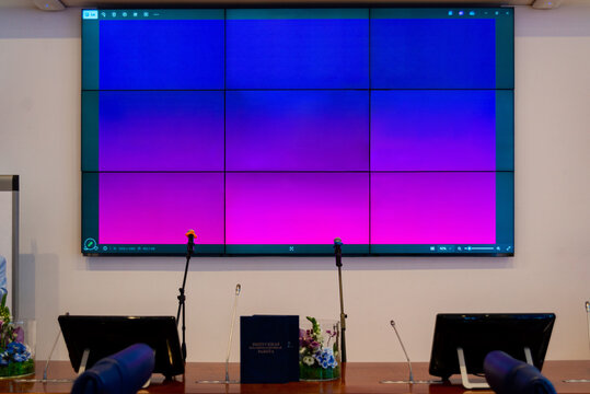 Panel display with colorful gradient background, conference setup