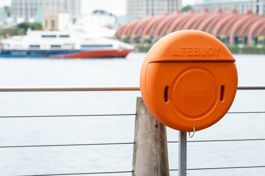 lifebuoy by river for rescue in emergency on cloudy day, floating rescue tool thrown to a person in the water to stop them from sinking, shallow depth of field, copy space