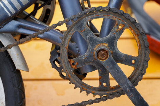 rusty bicycle chainring, crankset, and chain showing corrosion, oxidation, and mechanical wear, bicycle maintenance, neglected drivetrain components, repair needs, rust on cycling equipment