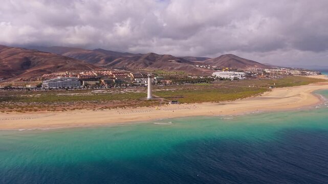 Ambient drone exploration of the Morro Jable town known for its beaches, like vast Playa del Matorral, with its Morro Jable Lighthouse. Drone POV of Fuertaventura Island. Lighthouse expedition.