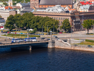 Naklejka premium Aerial view of the Stone Bridge carrying trams and traffic across the Daugava river into the historic centre of Riga, under a clear blue summer sky. Riga, Latvia.