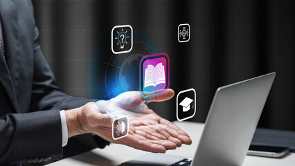 Fototapeta premium A businessman with a futuristic digital interface showing icons for education, artificial intelligence, and learning concepts in front of a laptop. E-learning technology and online education concept