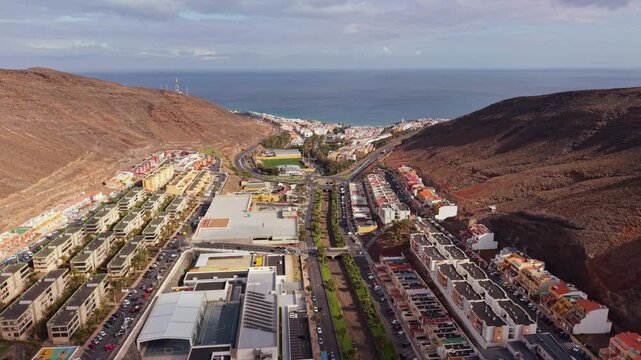 Ambient drone exploration of the Morro Jable town known for its beaches, like vast Playa del Matorral, with its Morro Jable Lighthouse. Drone POV of Fuertaventura Island.