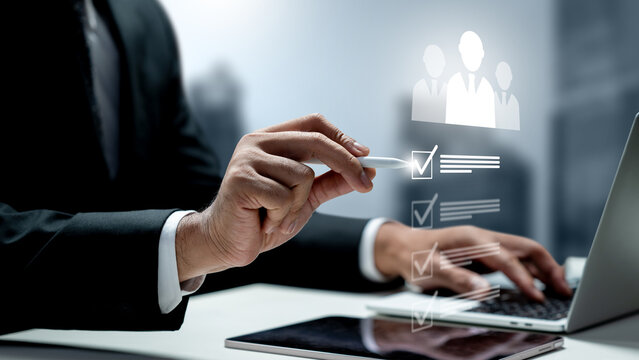 Businessman using a digital pen to select candidates from a holographic checklist on a laptop, symbolizing HR recruitment and talent acquisition. HR Recruitment concept