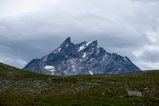 Dramatic Rocky Mountain Peaks of Romsdalseggen in M&oslash;re og Romsdal, Norway with Snow Patches and Overcast Sky