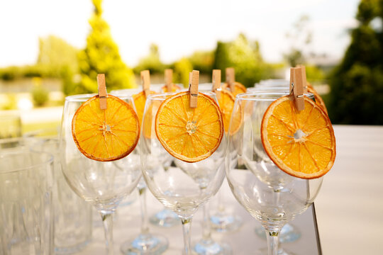 Empty cocktail glasses decorated with dried orange slices on bar counter, party drinks preparation and celebration concept