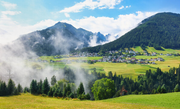 Village in green Austria Alps valley with big mountain in background near Kuthai