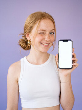 Smiling woman holding smartphone selfie style