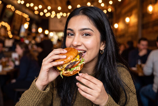 Woman enjoying a sandwich at night festival
