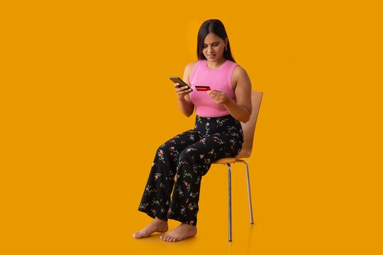 Indian girl shopping online through smartphone using credit card