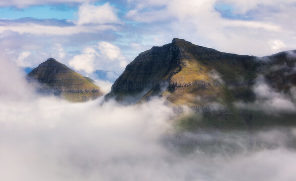 Mountain landscape view over clouds in Fareo islands.