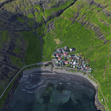 Aerial view of the Tjornuvik village and its beach located at a beautiful bay in the Faroe Islands, Denmark.