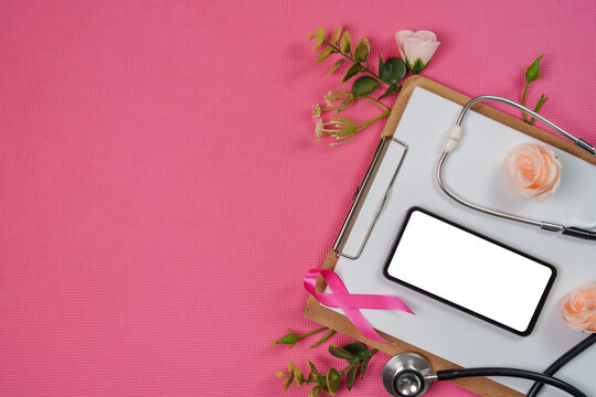 Breast cancer awareness concept with clipboard blank smartphone stethoscope and pink ribbon