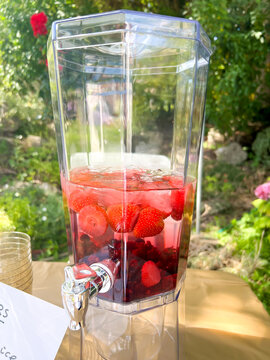 A dispenser containing water flavoured with summer fruits