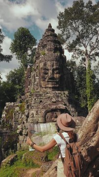 Solo Female Traveler Exploring Ancient Bayon Temple In Cambodia Jungle