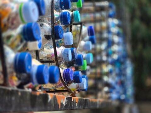 Ecobricks Made of Plastic Bottles Filled with Waste on Rack