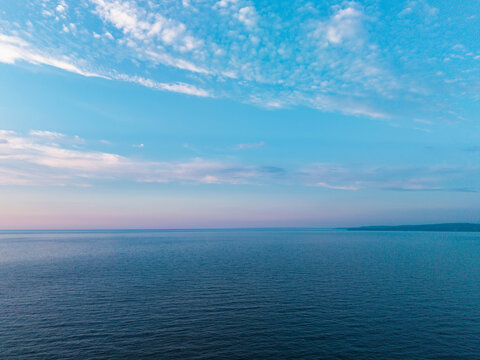 Beautiful drone landscape image of Pentire Headland and The Rumps in Cornwall and surrounding countryside during colorful Summer sunset