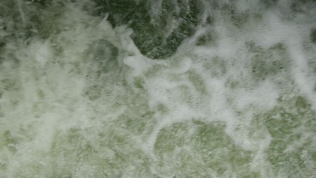 Rushing Turbulent River Water with White Foam Splashing Fast Current Motion