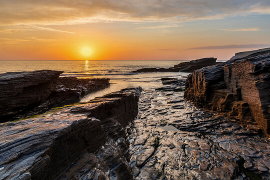 Beautiful stunning colorful vibrant Summer sunset at Trebarwith in Cornwall England