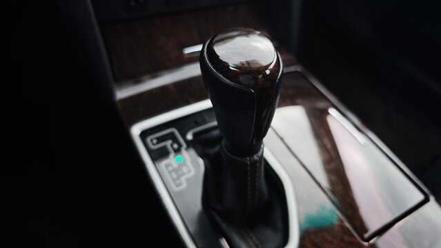 Close up of car automatic gear shift lever in park position, highlighting modern vehicle interior with wood trim
