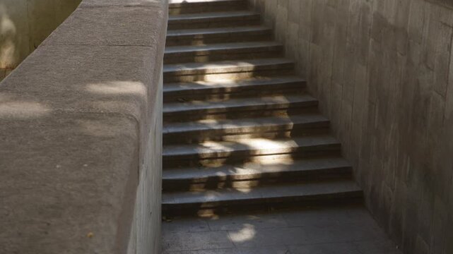 Man walking up wide concrete stairs in an urban underpass