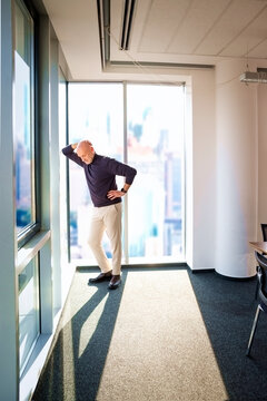 Businessman looking out city from a large window in the office