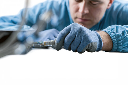 Technician connecting ethernet cable to network switch