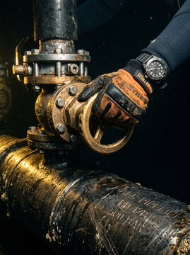 Diver Hand Turning Valve Wheel on High Pressure Subsea Pipeline