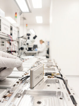 Gloved Hand Assembling Advanced Battery Modules in Cleanroom Laboratory