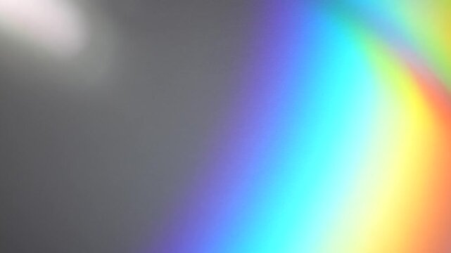 Soft rainbow refraction and blurred defocused light streaks appear on a dark abstract background. Concept digital design, banners, websites, advertising and editorial layouts.