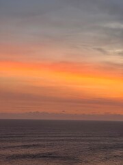 Fototapeta premium Ocean sunset with warm orange fading into a calm sea horizon