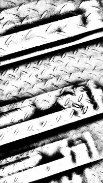 High-contrast black and white abstract background of industrial checkered diamond metal plate texture with diagonal lines and shadows.