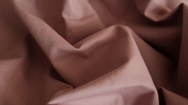 Dusty rose fabric shifting slowly, displaying its crumpled texture and soft, natural folds. Perfect for fashion branding campaigns, textile promotional videos, motion backgrounds, or interior design