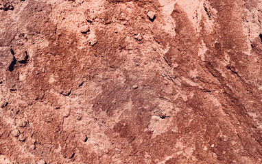 Fototapeta premium Orange red Sandstone Surface with dark layered ridges, rough grain and sandy erosion. Abstract desert Rock Texture Background with rugged natural pattern, copy space and closeup.