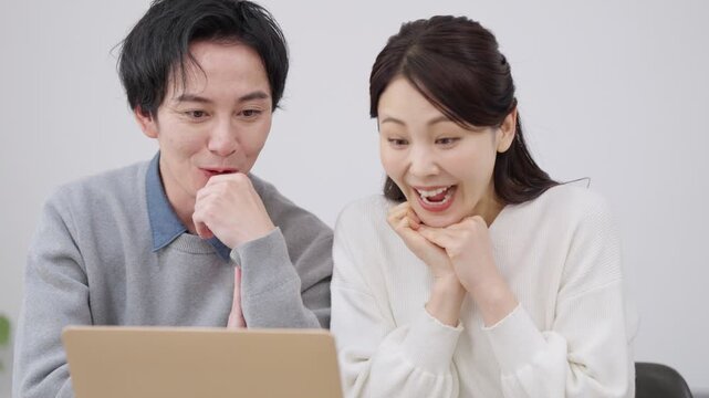 パソコンを見て驚く夫婦・カップル