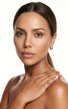 Radiant beauty portrait of a woman with a sun-kissed, glowing complexion and sleek dark hair pulled back into a neat ponytail