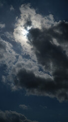 Obraz premium Vertical Shot of Dramatic Dark Storm Clouds Obscuring Bright Sun