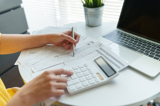 A person Managing household expenses with calculator, receipts and laptop for accurate budgeting, financial planning and bill review.