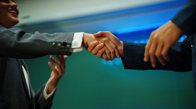 Business professionals shaking hands after a successful meeting, symbolizing partnership, trust and agreement.
