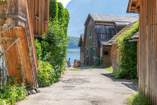 Traditional Wooden Boathouse on Hallstatt Lake Shore with Mountains and Kids Slide in Austria Europe. Narrow simple rural street in village