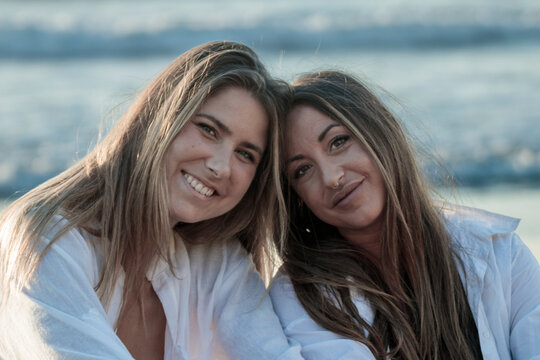Happy young women smiling together on beach